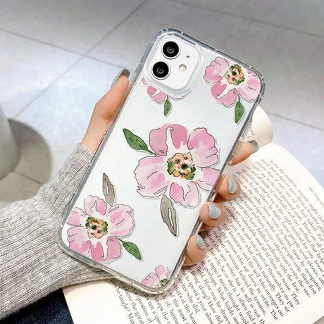 a woman holding a phone case with pink flowers on it