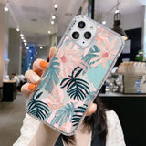 a woman holding up a phone case with a tropical print