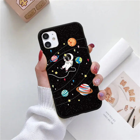 a woman holding a phone case with a space theme