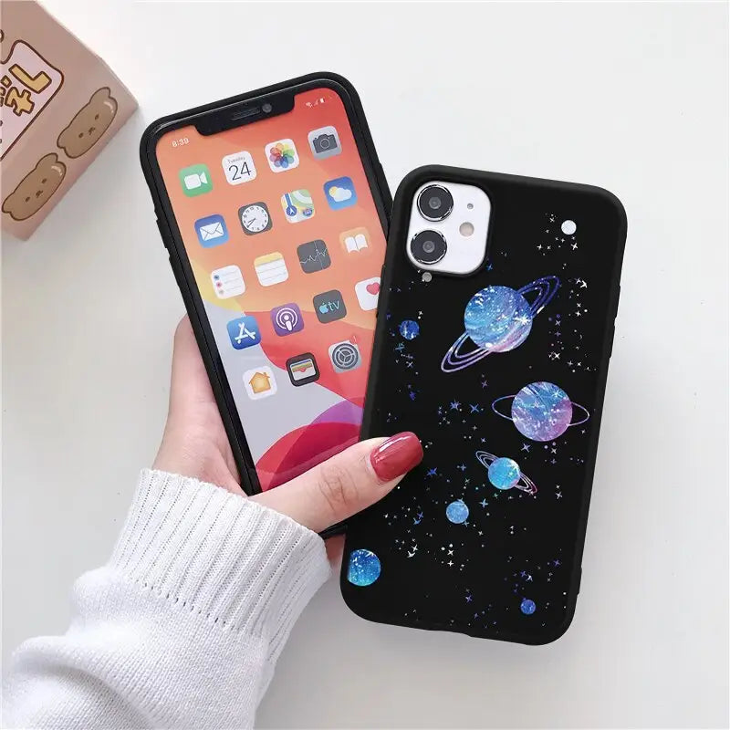 a woman holding a phone case with planets on it