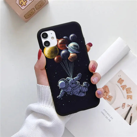 a woman holding a phone case with a space theme