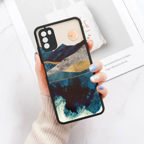 a woman holding a phone case with a mountain scene