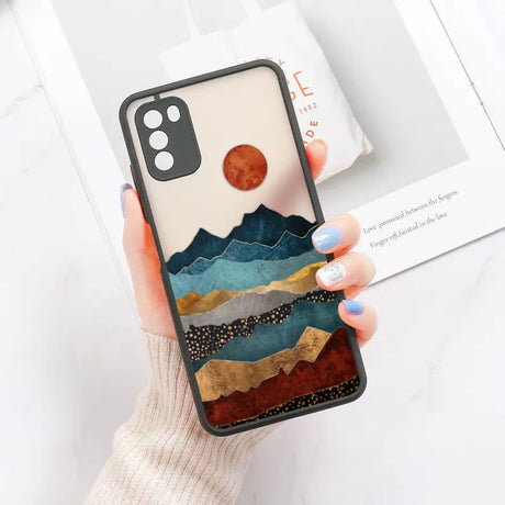 a woman holding a phone case with a mountain scene