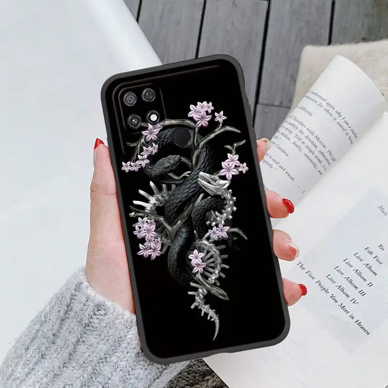 a woman holding a phone case with a black and white bird on it