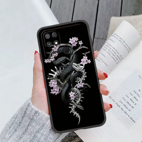 a woman holding a phone case with a black and white bird on it