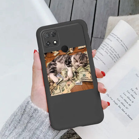 a woman holding a phone case with a cat on it