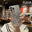 a woman holding up a phone case with a leopard print