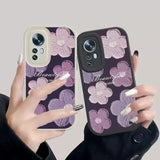 a woman holding a phone case with a purple flower pattern