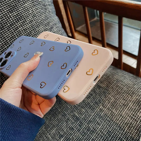 a woman holding a phone case with a heart pattern