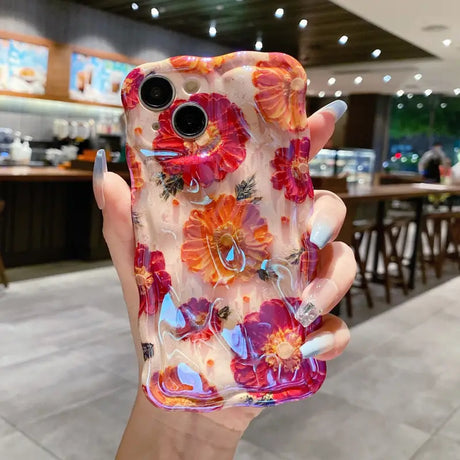 a woman holding a phone case with flowers on it