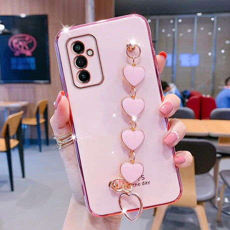 a woman holding a phone case with heart charms