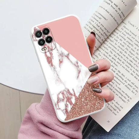 a woman holding a pink and white marble phone case