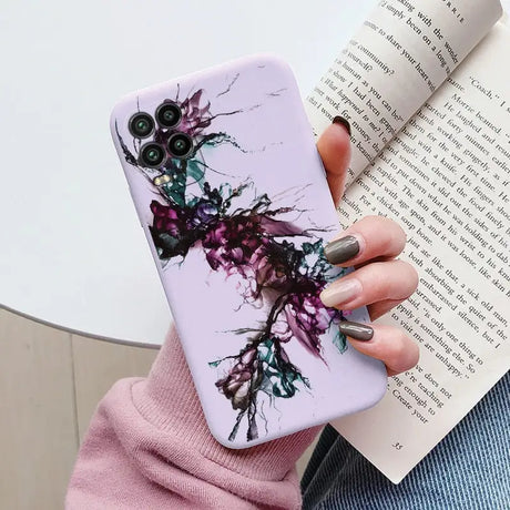 a woman holding a phone case with a purple flower design