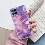 a woman holding a phone case with a purple marble pattern
