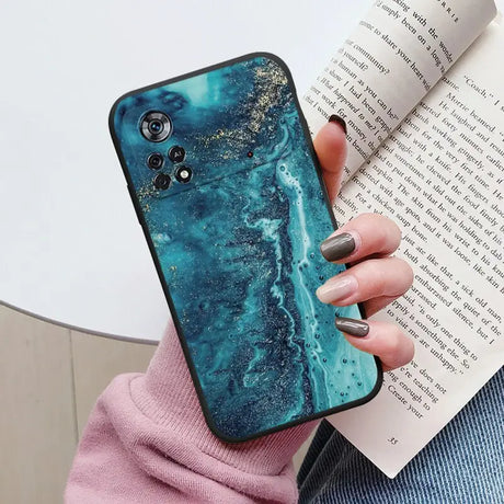 a woman holding a phone case with a blue marble pattern