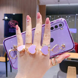 a woman holding up her phone case with two rings