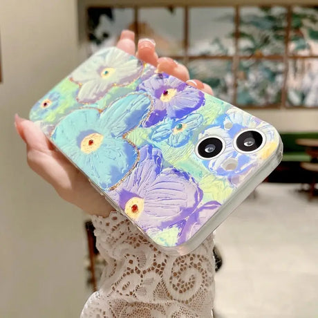 a woman holding a phone case with a painting on it