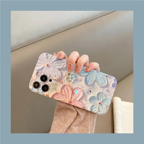 a woman holding a phone case with flowers on it