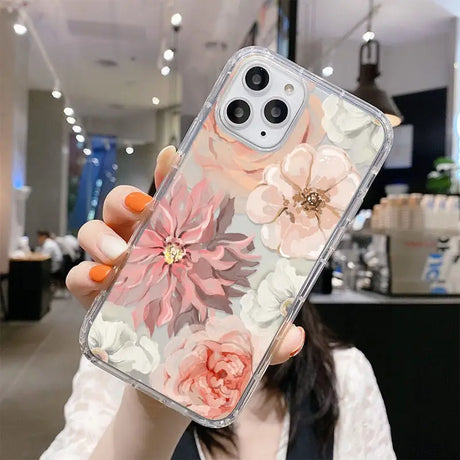 a woman holding up a phone case with flowers on it