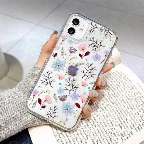 a woman holding a phone case with flowers on it