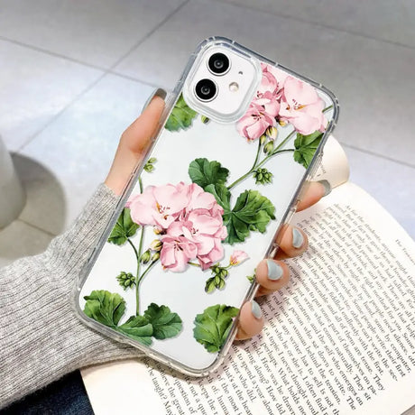 a woman holding a phone case with pink flowers on it