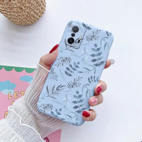 a woman holding a phone case with a floral pattern