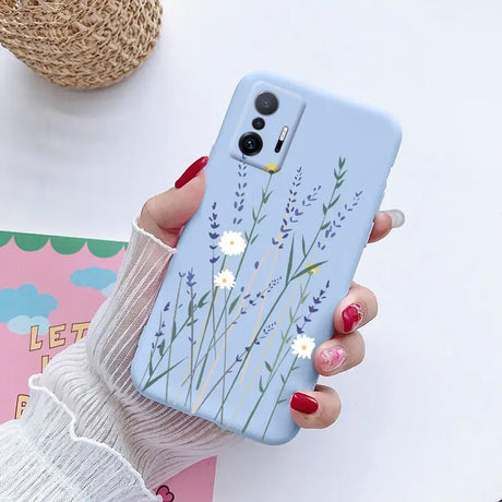 a woman holding a phone case with flowers on it