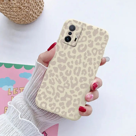 a woman holding a phone case with a leopard print