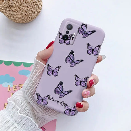 a woman holding a phone case with butterflies on it