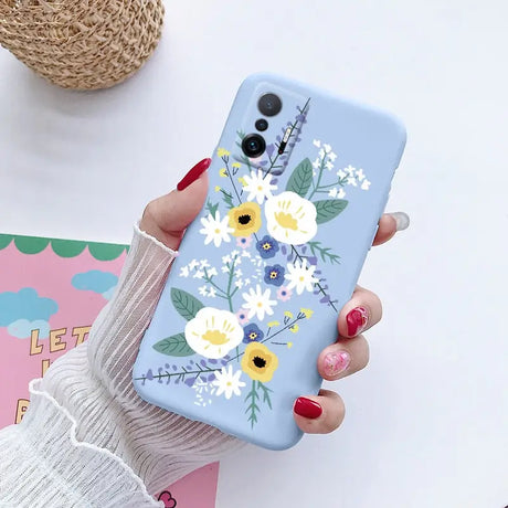 a woman holding a phone case with flowers on it