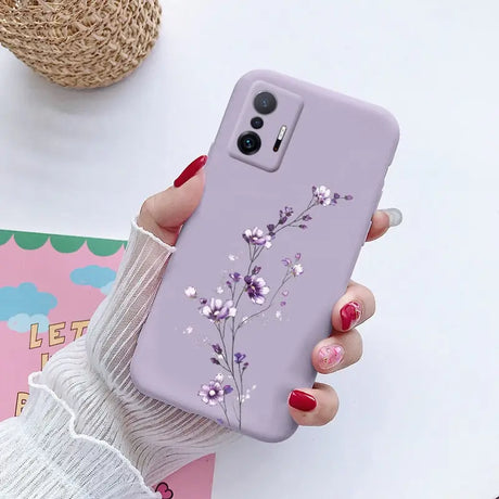 a woman holding a phone case with flowers on it