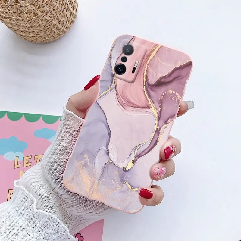 a woman holding a phone case with a pink and purple elephant