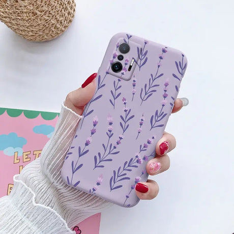 a woman holding a phone case with purple flowers on it