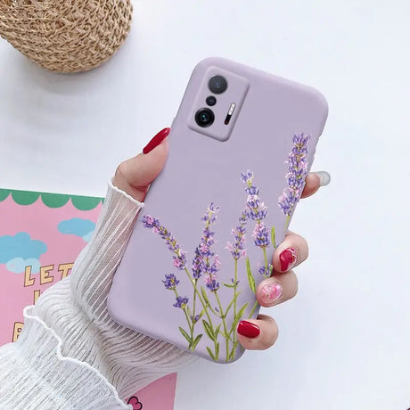 a woman holding a phone case with lavender flowers on it