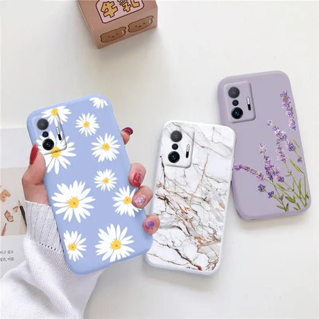 a woman holding a phone case with white flowers on it