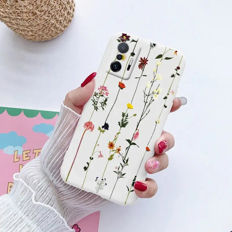 a woman holding a phone case with flowers on it