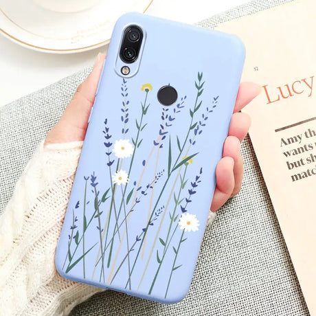 a woman holding a phone case with flowers on it