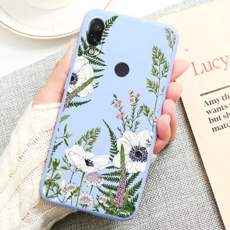 a woman holding a phone case with flowers on it