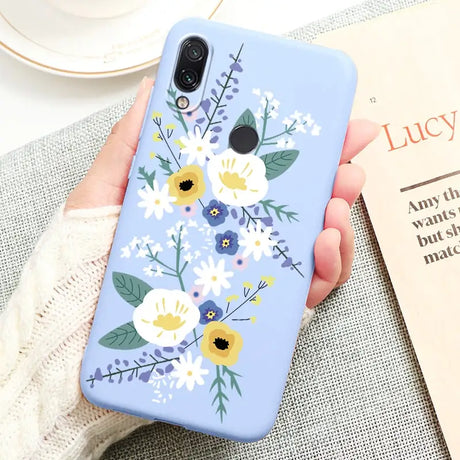 a woman holding a phone case with flowers on it