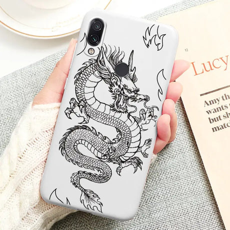 a woman holding a phone case with a dragon on it