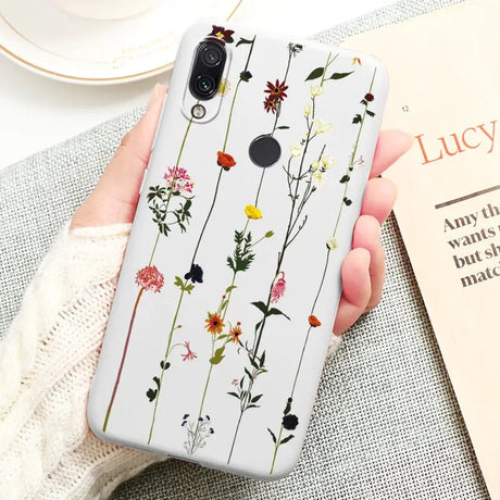 a woman holding a phone case with flowers on it