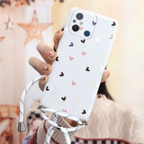 a woman holding a phone case with hearts on it