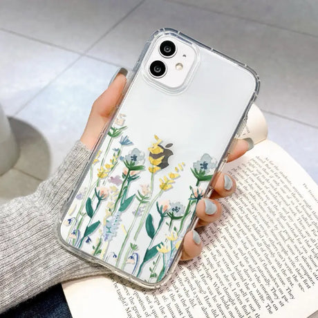 a woman holding a phone case with flowers on it