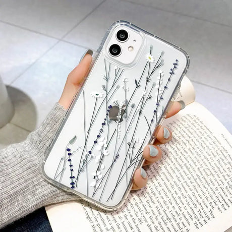 a woman holding a phone case with a white flower design