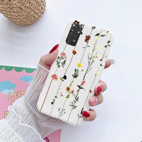 a woman holding a phone case with flowers on it