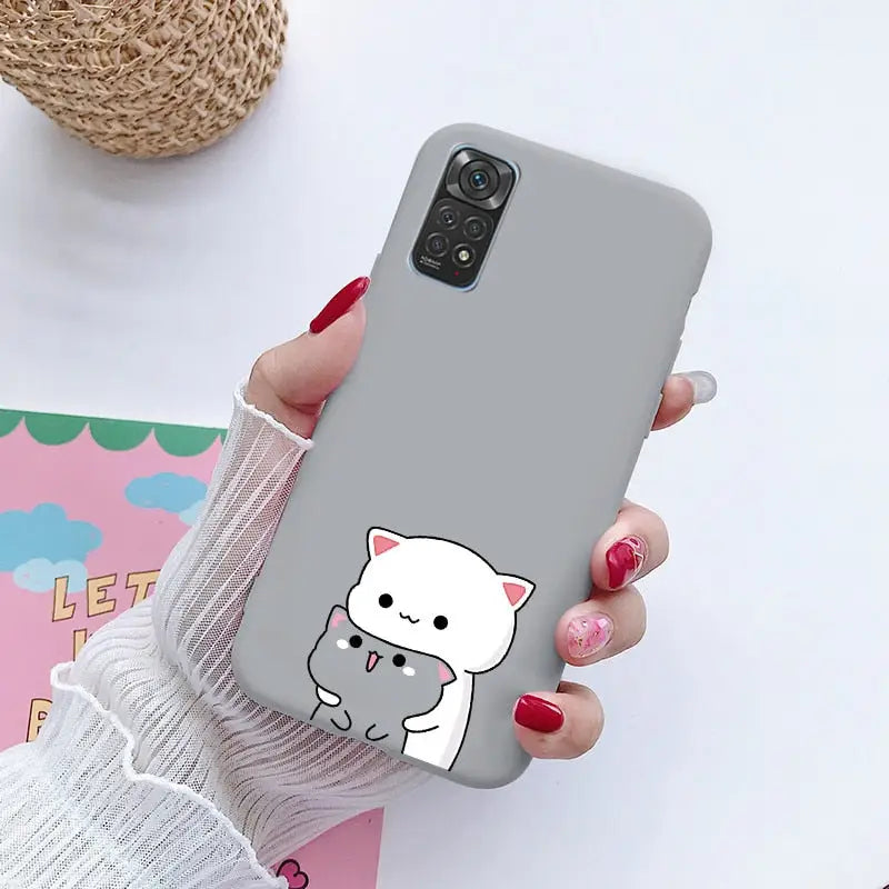 a woman holding a phone case with a cat on it