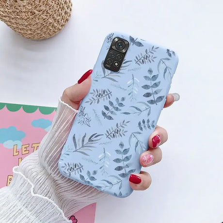 a woman holding a phone case with a floral pattern