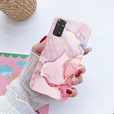 a woman holding a phone case with a pink marble pattern