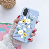 a woman holding a phone case with flowers on it