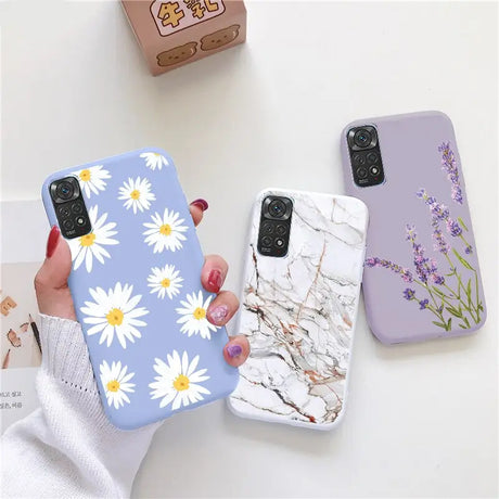 a woman holding a phone case with white flowers on it